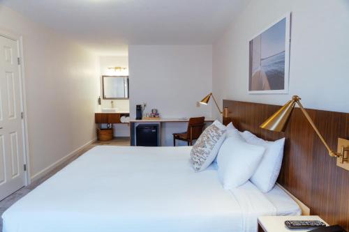 een slaapkamer met een groot bed en een bureau bij Skaneateles Suites Boutique Hotel in Skaneateles