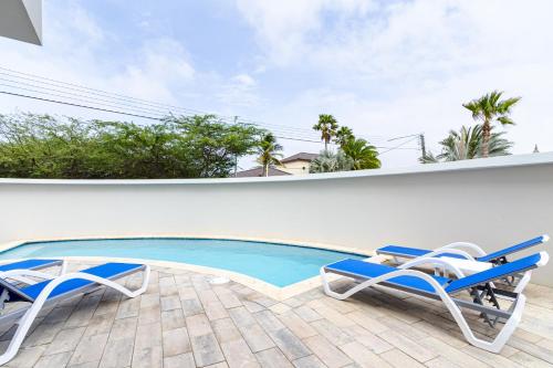 a patio with two chairs and a swimming pool at Summerside 4 Rooi Santo 10-A in Palm-Eagle Beach