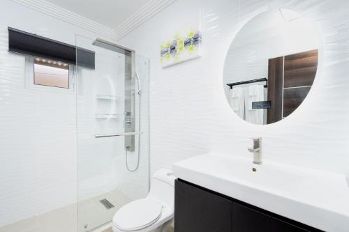 a bathroom with a toilet and a sink and a mirror at Solito 52 in Oranjestad