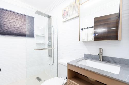 a white bathroom with a sink and a shower at Solito 52 in Oranjestad