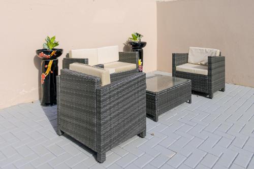 three wicker chairs and a chair and a table at Solito 52 in Oranjestad