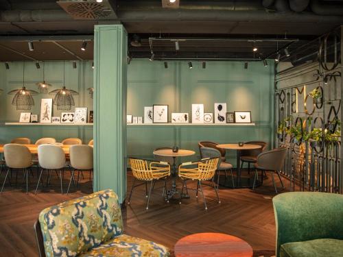 a restaurant with tables and chairs in a room at Motel One Saarbrücken in Saarbrücken
