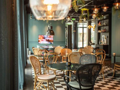 a restaurant with tables and chairs and a checkered floor at Motel One Saarbrücken in Saarbrücken