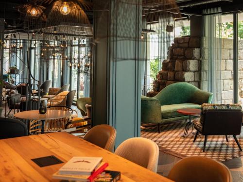 a restaurant with tables and chairs in a room at Motel One Saarbrücken in Saarbrücken
