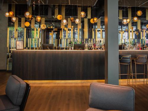 a bar in a restaurant with two stools at Motel One Saarbrücken in Saarbrücken