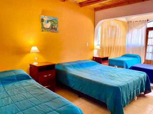 een slaapkamer met 2 bedden in een kamer met gele muren bij El Portal de Cerrillos, Hostería de Campo in Cerrillos