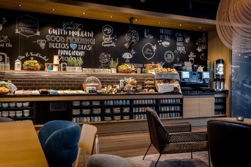 un restaurant avec un comptoir où vous pourrez manger dans l'établissement Motel One Stuttgart-Mitte, à Stuttgart