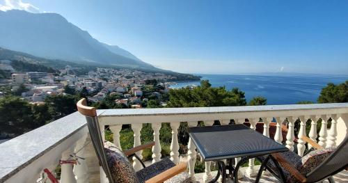 a table and chairs on a balcony overlooking the water at Apartman Saric K&M in Baška Voda