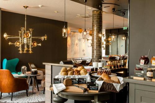 a bakery with a table with bread on it at Motel One München-Westend in Munich