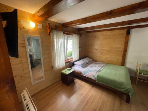 een slaapkamer met een bed in een houten hut bij Zabljak studio apartment 1 in Žabljak