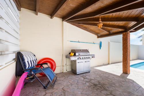 a patio with a grill and a table and chairs at Koyari 36-F in Palm-Eagle Beach