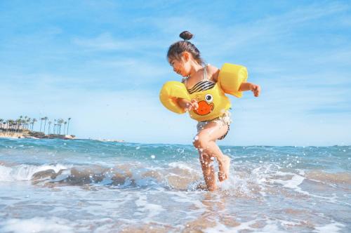 a little girl running in the water with a life preserver at Koyari 36-F in Palm-Eagle Beach