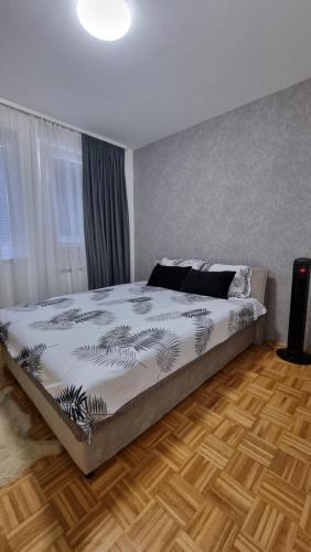 um quarto com uma cama grande e piso em madeira em Aya apartment Sarajevo em Sarajevo