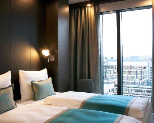 pokój hotelowy z łóżkiem i dużym oknem w obiekcie Motel One London-Tower Hill w Londynie