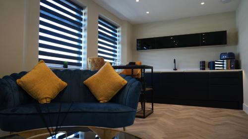 a living room with a blue couch and a kitchen at Five Apartments in Blackpool