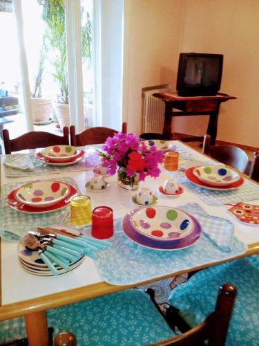 a table with plates and flowers on top of it at The Secret Garden Maratea - Casa di Sery in Maratea