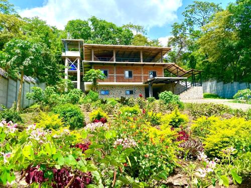 a house in the middle of a garden with flowers at Villa Ometepe in Mérida