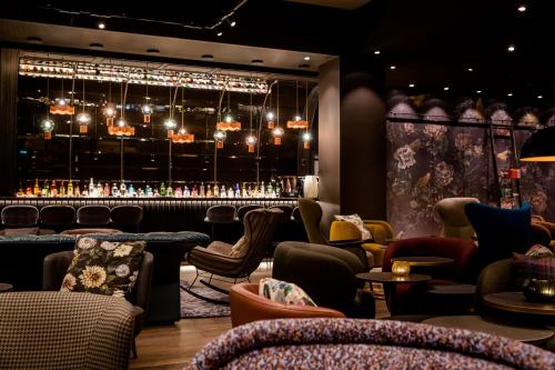 um restaurante com um bar com cadeiras e mesas em Motel One Manchester-St. Peter´s Square em Manchester