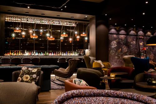 a restaurant with a bar with chairs and tables at Motel One Manchester-St. Peter´s Square in Manchester