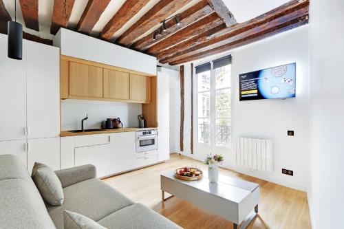 a living room with a couch and a table at Studio 2P renovated rue des Archives Marais Clim 2 in Paris