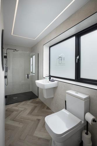 a bathroom with a toilet and a sink and a window at Five Apartments in Blackpool
