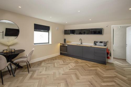 a kitchen with a sink and a table and a counter at Five Apartments in Blackpool