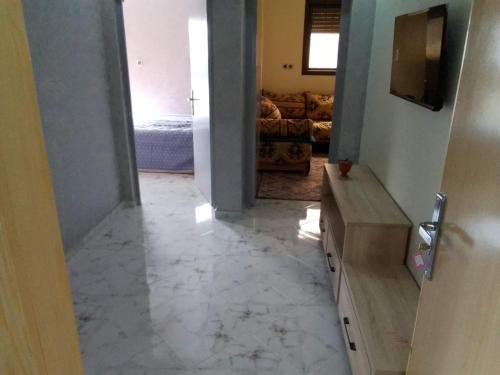 ein Wohnzimmer mit Marmorboden und einem TV in der Unterkunft إقامة أحمد 1 in Agadir