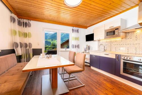eine Küche und ein Esszimmer mit Holzdecke in der Unterkunft Appartement Am Tatscherlehen in Piesendorf