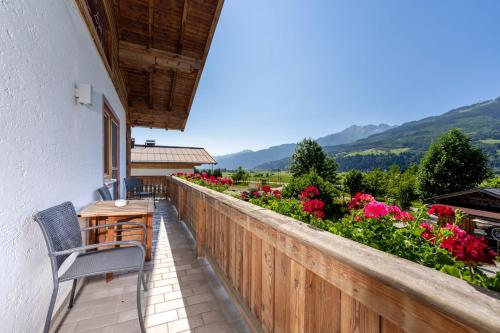 a balcony with a table and chairs and flowers at Appartement Am Tatscherlehen in Piesendorf