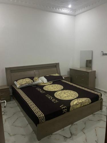 a bedroom with a bed with a black and gold comforter at Marong Na kordaa in Sere Kunda