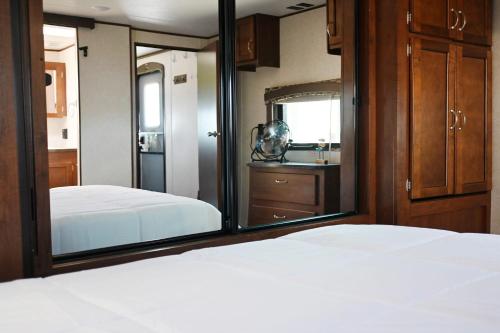 Bolivar PeninsulaにあるBay View Glampingのベッドルーム1室(ベッド2台、鏡付)