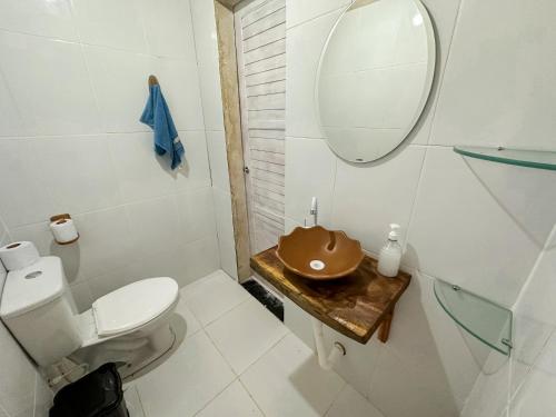 uma casa de banho com um WC, um lavatório e um espelho. em Vila da Sereia hostel e pousada em Icaraí