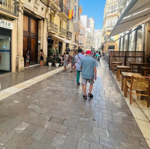 a group of people walking down a street at Emilysuites - Malaga Centro Historico in Málaga