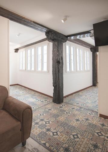 a living room with a pillar and a couch in a room at Emilysuites - Malaga Centro Historico in Málaga