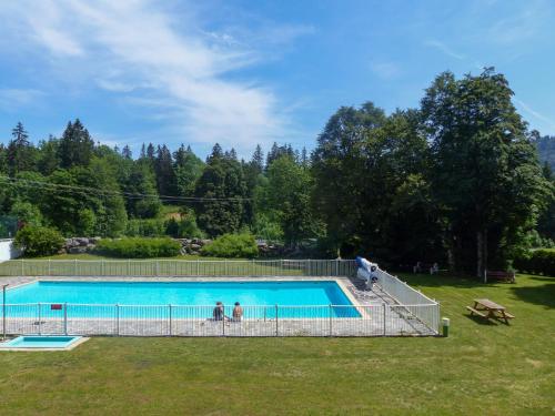 a swimming pool with two people standing next to it at Appartement Les rousses, Jura in Les Rousses