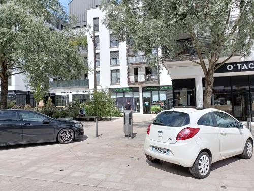 a white car parked in front of a building at Studio Cosy neuf + lit bébé à 4 minutes RER A in Montévrain