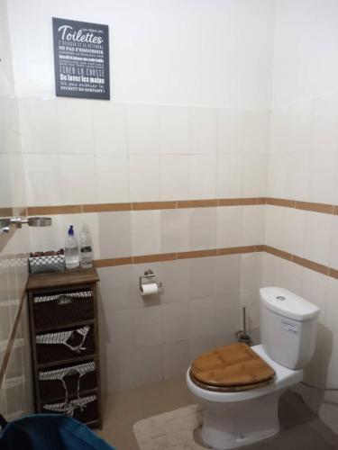 a bathroom with a toilet with a wooden seat at Comme Chez Soi 1 in Pointe-Noire
