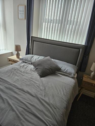 a bedroom with a large white bed with a window at Saltwater Edge Apartment in Portrush