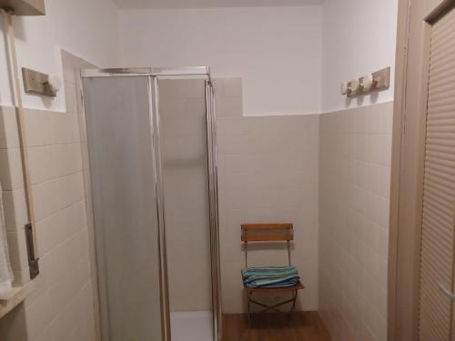 uma casa de banho com um chuveiro e uma cadeira de madeira em Dream10 em Parabiago