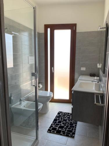 e bagno con servizi igienici, lavandino e doccia. di Olbios Apartment a Olbia