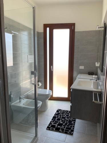a bathroom with a toilet and a sink and a shower at Olbios Apartment in Olbia