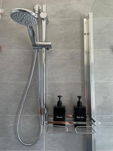 a shower in a bathroom with two soap dispensers at Olbios Apartment in Olbia