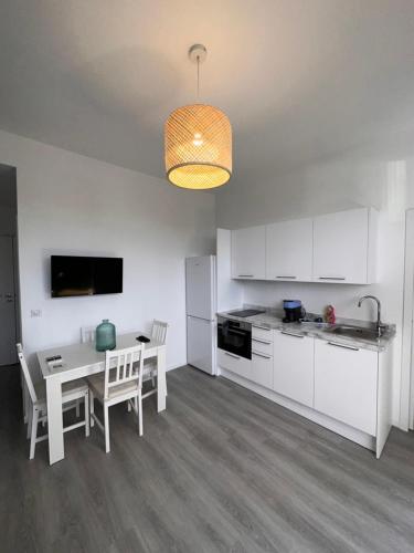 une cuisine avec des armoires blanches et une table avec des chaises dans l'établissement Charmant 2 Pièces, à Antibes