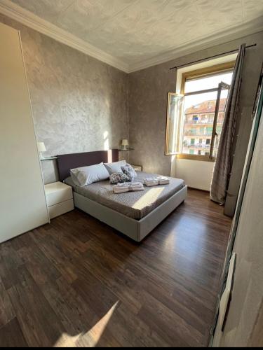 a bedroom with a bed and a large window at Casa vacanze Paglino in Ventimiglia