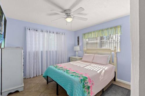 1 dormitorio con 1 cama y ventilador de techo en Flirty Flamingo with Private Heated Pool, Game Room, and AMAZING Covered Outdoor Living en Panama City Beach