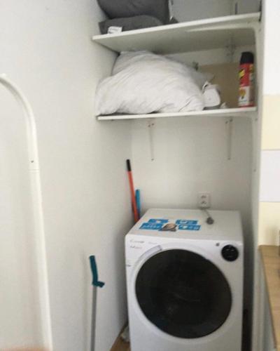 een wasmachine en droger in een hoek van een kamer bij Snug room close to metro Palmovka in Praag