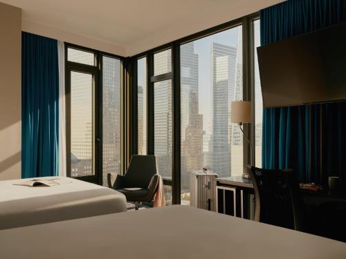 ein Hotelzimmer mit einem Bett, einem Stuhl und einem Fenster in der Unterkunft The Cloud One New York-Downtown, by the Motel One Group in New York