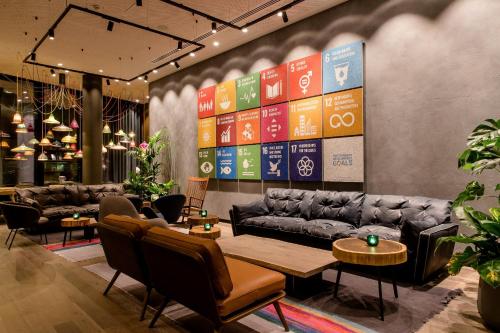 a restaurant with couches and tables and chairs at Motel One Bonn-Hauptbahnhof in Bonn