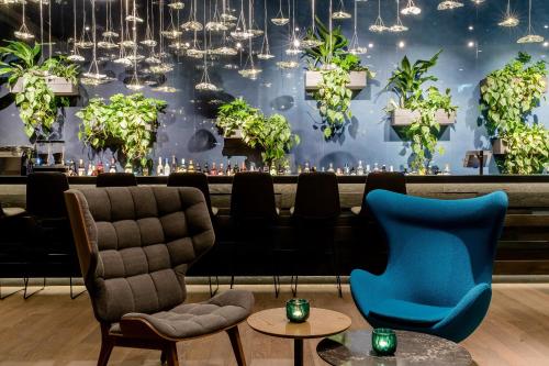 a restaurant with chairs and a bar with plants at Motel One Bonn-Hauptbahnhof in Bonn