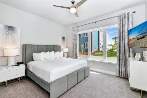 a bedroom with a bed and a large window at Magnificent Condo w/ Reunion Water Park Access near Disney by Spectrum Resort Orlando by Rentyl - B7 #128 in Kissimmee